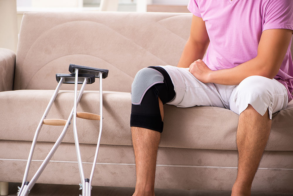 Photo of a person sitting on a couch with a knee brace on